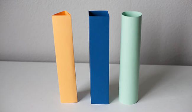 Three pieces of paper folded into columns as circle, square, and triangle